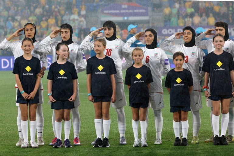 Iranian Women's Football Team Raises Hands in Salute During Anthem as Crowd Boos and Waves Pre-1979 Flag Amid Violence in Iran