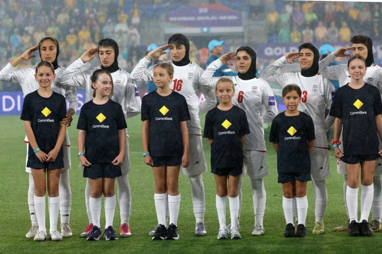 Iranian Women's Football Team Raises Hands in Salute During Anthem as Crowd Boos and Waves Pre-1979 Flag Amid Violence in Iran